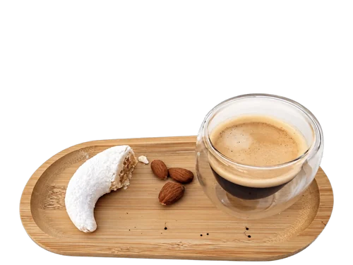 Corne de gazelle entamée sur un plateau en bambou, avec des amandes et un café